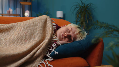 Portrait of young woman sitting on sofa at home