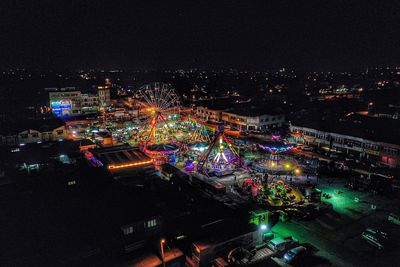 High angle view of illuminated city against sky at night