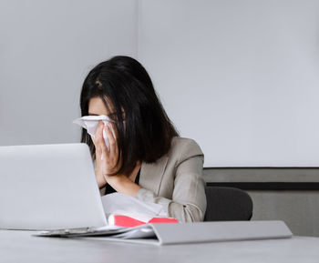 Woman using mobile phone while sitting on table