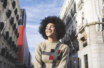 Young woman smiling while standing in city