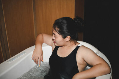 Side view of young woman exercising at home