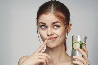 Close-up of young woman holding drinking glass