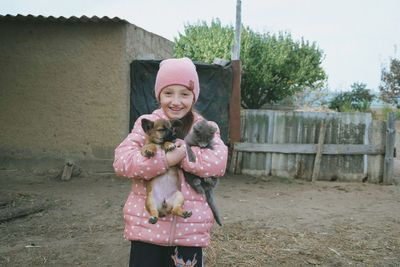 Child with little dog and cat playing at home. girl with puppy and kitty. kissing, hugging, playing