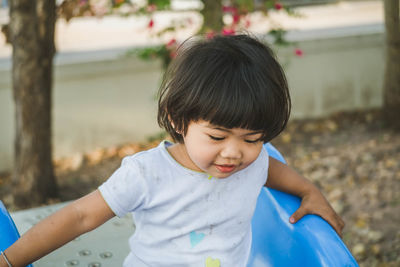 Cute girl playing on slide at park