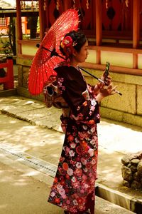 Side view of woman holding umbrella