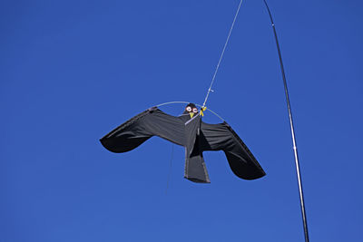 Low angle view of kite against clear blue sky