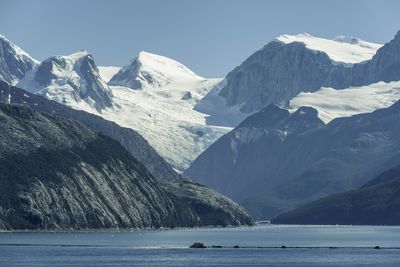 Scenic view of snowcapped mountains by sea against sky