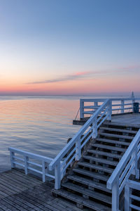 Pier over sea against sky during sunset