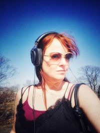 Portrait of young woman wearing sunglasses against sky