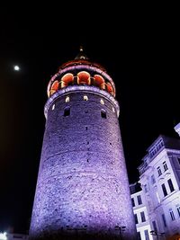 Low angle view of illuminated building against sky at night