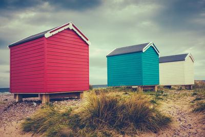 Beach hut on field against sky