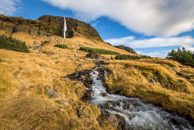 Scenic view of waterfall against sky