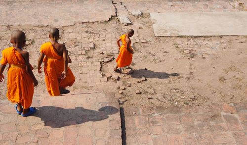 Men on cross against orange wall