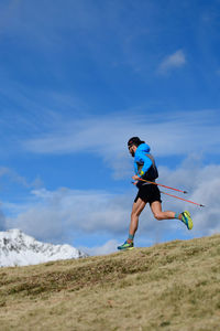 A man trains for ultra run trail in the mountains in the fall with the first snow on the mountains