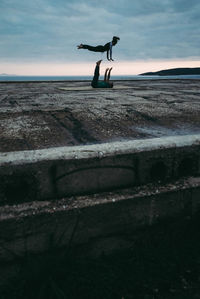 Man jumping in sea against sky