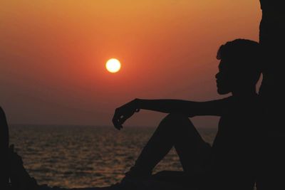 Silhouette people against sea during sunset
