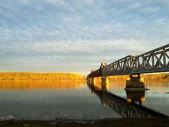 Bridge over river against cloudy sky