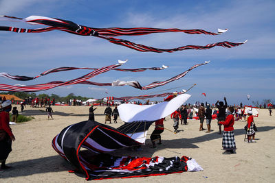 People enjoying bali kite festival against sky