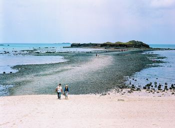 People on beach against sky