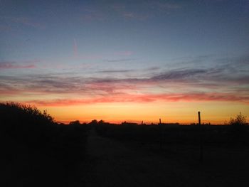 Scenic view of silhouette field against sky at sunset