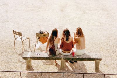 Rear view of female friends sitting on bench
