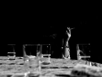 Midsection of man and wine glass on table at restaurant