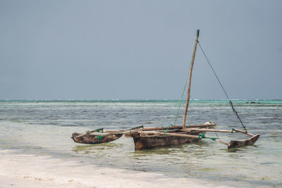 Ngalawa boat in sea against clear sky