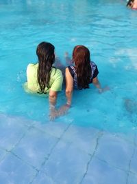 Rear view of women swimming in pool