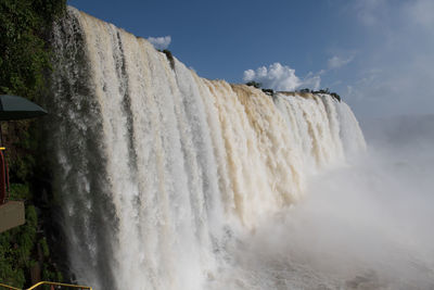 Scenic view of waterfall against sky