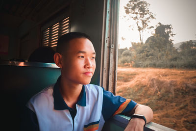 Portrait of boy sitting in window