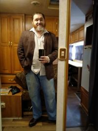 Full length portrait of young man standing at home