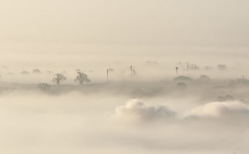 Scenic view of fog covered landscape against sky