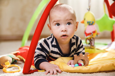 Portrait of cute baby boy sitting on bed at home