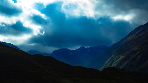 Scenic view of mountains against cloudy sky