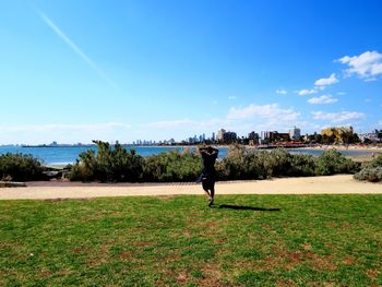 Woman standing on field against sky