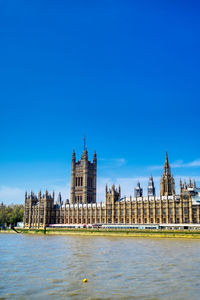 View of river and buildings against blue sky