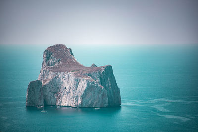 Panoramic view of rock formation in sea against sky