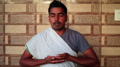 Portrait of man standing against wall