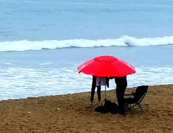 Woman with red umbrella on beach