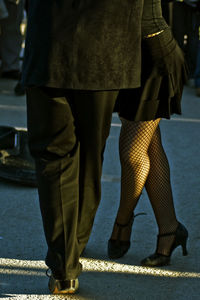 Low section of couple standing on road