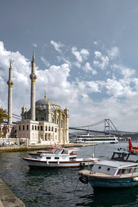 Boats sailing in harbor by ortaköy mosque