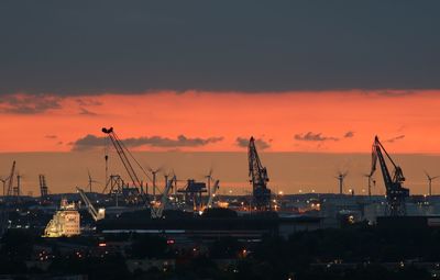 Illuminated commercial dock against sky at sunset