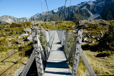 Footbridge over lake against mountains