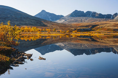 Reflection of rondane mountains in a small lake. rondane national park, norway, europe autumn colors