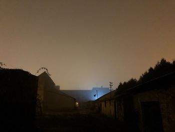 Low angle view of silhouette buildings against sky at night