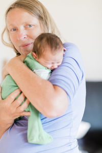 Portrait of grandmother holding baby boy at home