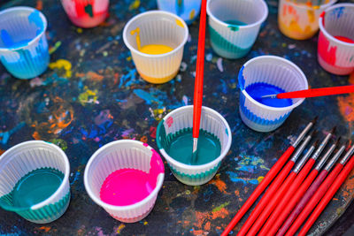 High angle view of watercolor paints in disposable cups