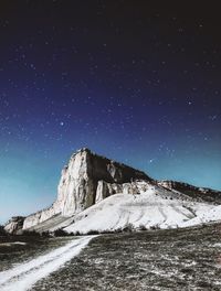 Scenic view of snowcapped mountain against sky at night