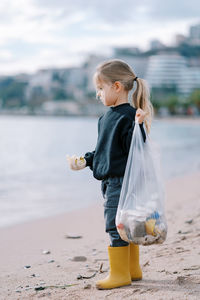 Side view of boy standing at beach