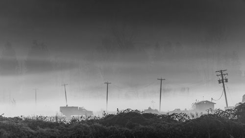 Electricity pylon on field against sky